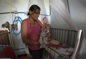 A woman holds her undernourished baby in a hospital in Maracay, Aragua state, Venezuela